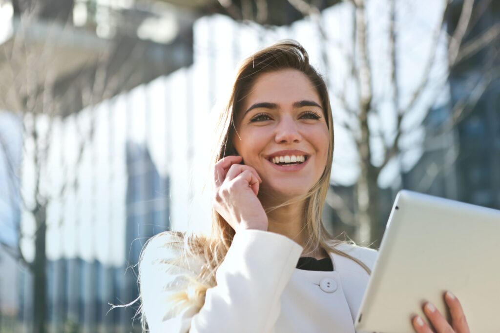 Woman smiling holding tablet